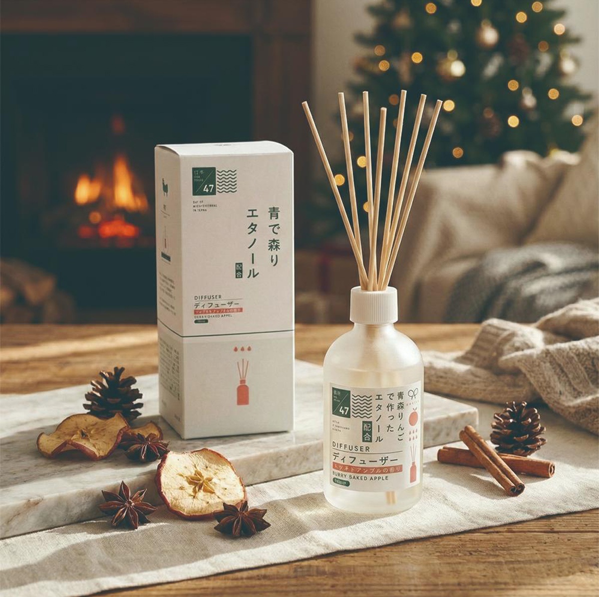 KYARA INNOVATE 擴香竹，以青森蘋果製成的再生乙醇，搭配 Baked Apple 香味，呈現溫馨生活感，背景有壁爐與聖誕樹，營造節日氛圍