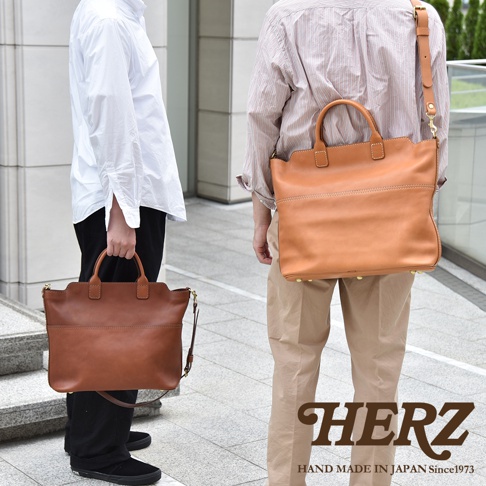 兩款棕色皮革托特包，一款由左側人物手提，另一款由右側人物斜背，均為大容量兩用設計。