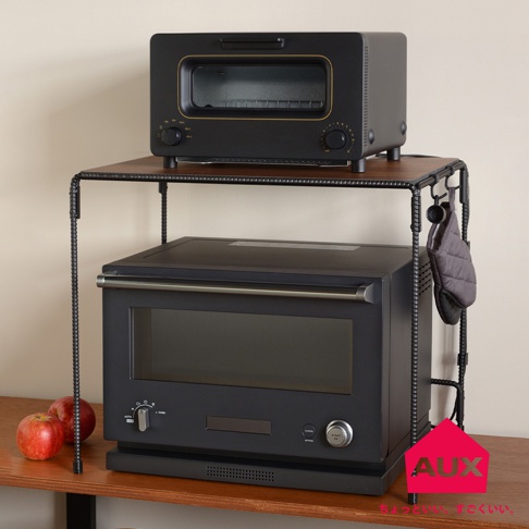 BOW 廚房工業風單層置物架，黑色金屬框架搭配木紋層板，上方擺放黑色烤箱，下方為黑色微波爐，側邊掛有灰色隔熱手套。