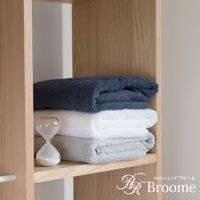 今治純棉質感菱紋吸水長浴巾，展示深藍、純白、淺灰三色，整齊疊放於木質層架上，一旁擺放著一個透明的沙漏。