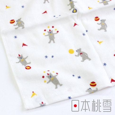 白色紗布毛巾印有「小小馬戲團」圖案，包括灰色小熊在玩雜耍、拋接球，以及小旗幟和星星點綴。