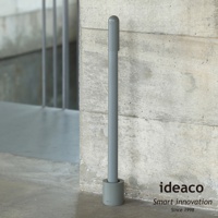 ideaco 品牌長柄鞋拔，附有圓柱形收納座，立於粗糙的水泥牆旁，上面印有 ideaco Smart innovation Since 1998 字樣。