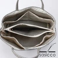 三河木綿刺子織托特包，黑色與白色格紋，內部有多個隔層和拉鍊口袋，內襯為黑色圓點圖案。