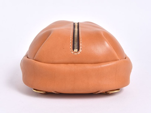 棕色皮革立體運動斜背包，頂部有拉鍊開合，兩側有金色金屬環。