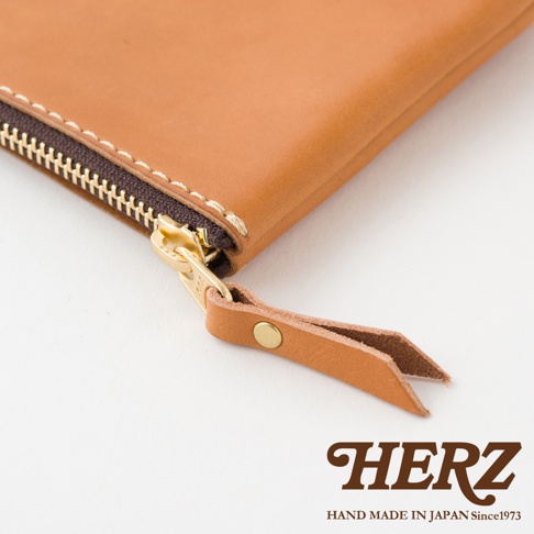 職人手作皮革長方形拉鍊收納包，採用淺棕色皮革，搭配金色拉鍊與同色皮革拉袢，縫線清晰，質感細膩。
