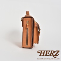 職人手作的淺棕色皮革立體口袋兩用單肩包，側面有拉鍊開合，搭配金色五金配件。