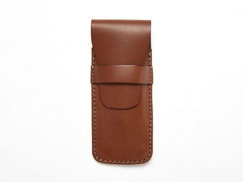 職人手作皮革鋼筆收納筆套，溫暖的棕色皮革，帶有縫線細節，並以皮帶扣固定，設計簡約實用。