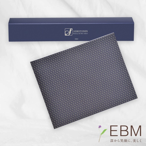 深藍色長盒內有「SEROTONIN Beauty & Diet sheet EBM」字樣。下方為一張深灰色片狀產品，表面佈滿規則的六角形紋路。