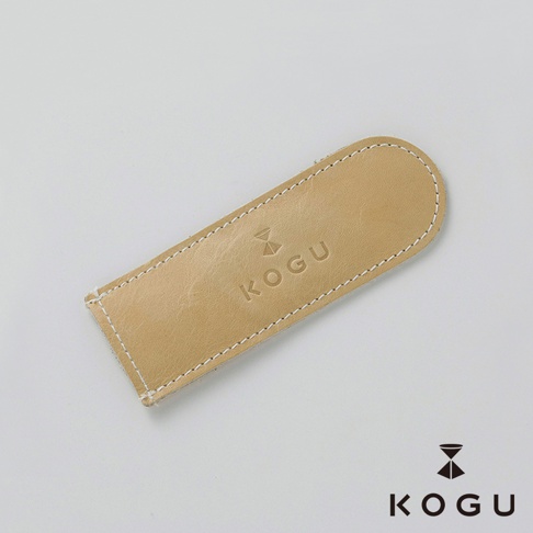 淺棕色植鞣皮革製成的咖啡器具握柄隔熱套，表面壓印有 KOGU 品牌標誌，以白色縫線包邊，設計簡約。