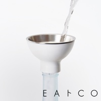 日製漏斗組，白色霧面外觀，內側為不鏽鋼材質。漏斗上方流入液體，下方連接至一個淺藍色玻璃瓶口。