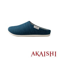 一隻藍色牛仔布紋理的包覆式室內拖鞋，鞋面有白色品牌標籤，搭配米白色鞋底。