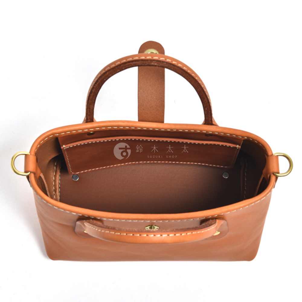 棕褐色皮革迷你托特包，頂部視角，展示雙提把、內袋隔層、側邊 D 型環及車縫細節。