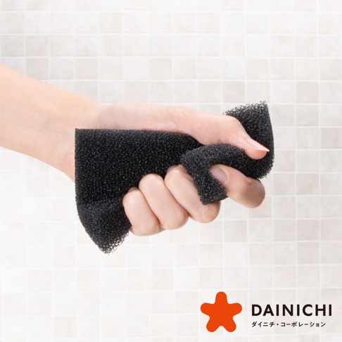 DAINICHI 超耐用除污快乾海綿8入組，黑色泡棉材質，手部握持特寫，背景為淺色磁磚