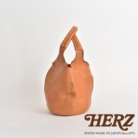 職人手作皮革球形肩掛托特包，淺棕色，以堅固的縫線細節呈現其圓潤飽滿的球形輪廓，搭配雙提把設計。