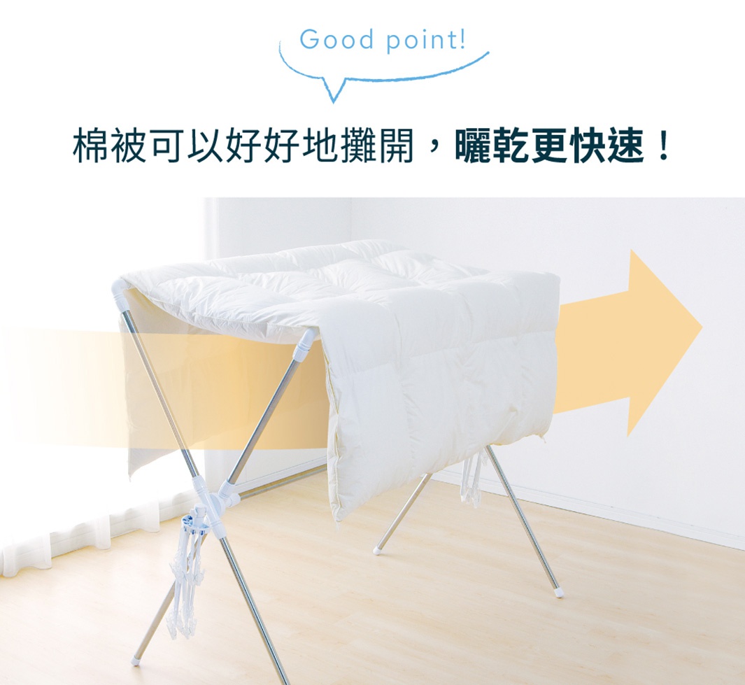 不鏽鋼X型曬衣架，架有白色棉被，架身為銀色不鏽鋼管，白色塑膠連接件，並附有幾個晾衣夾。